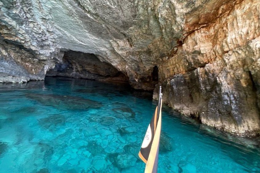 A clear blue cave pool with a wooden boat. 5