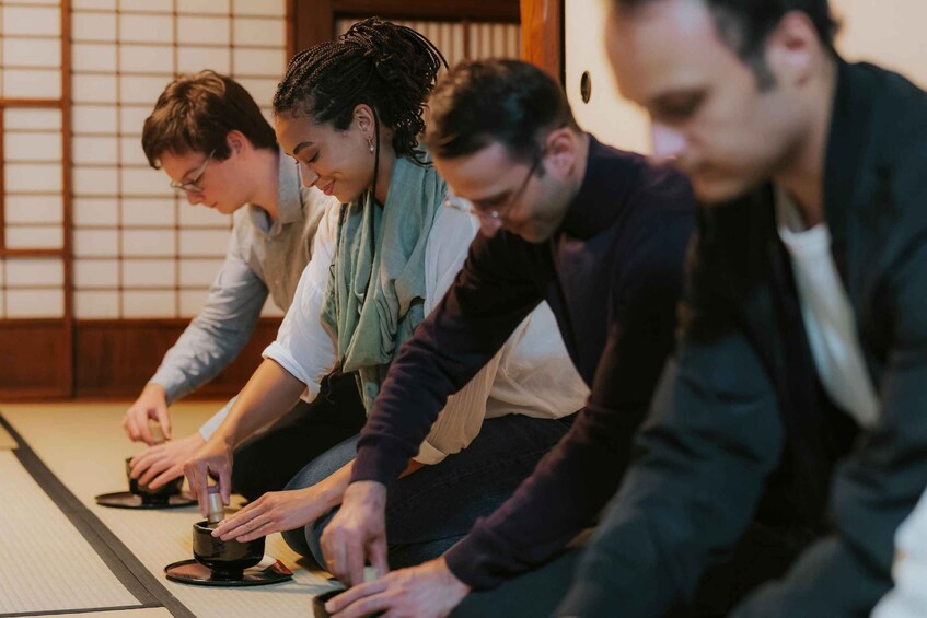 People sitting on tatami mats in a traditional Japanese room. 1