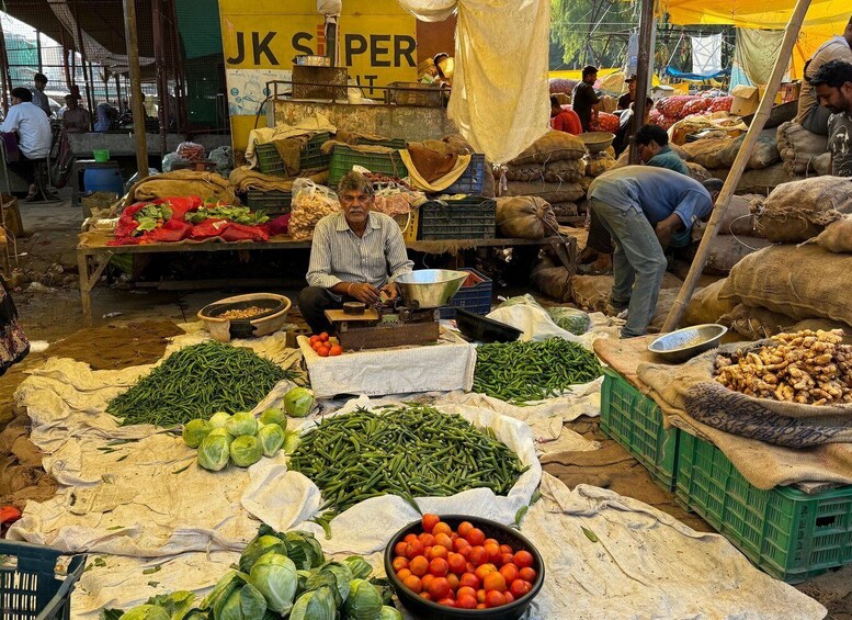 A bustling market with various vegetables like tomatoes, green beans, and cabbage displayed on cloth. 5