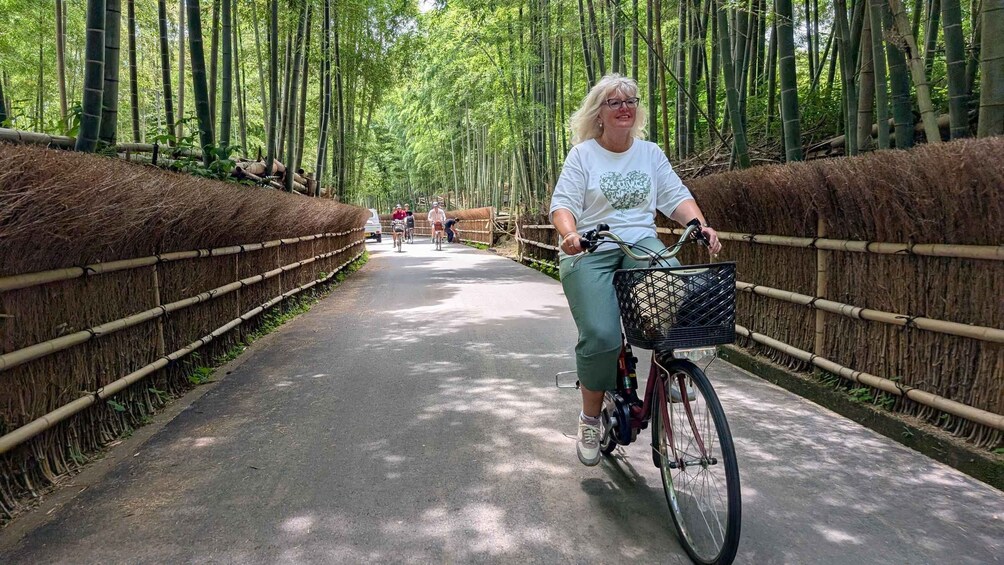 A person riding a bicycle on a bamboo-lined path in a forested area. 1