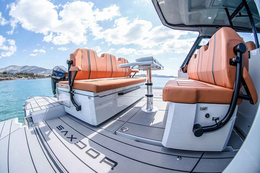 A boat deck with two orange cushioned seats, a steering wheel, and a 'SIXOPR' logo. 2