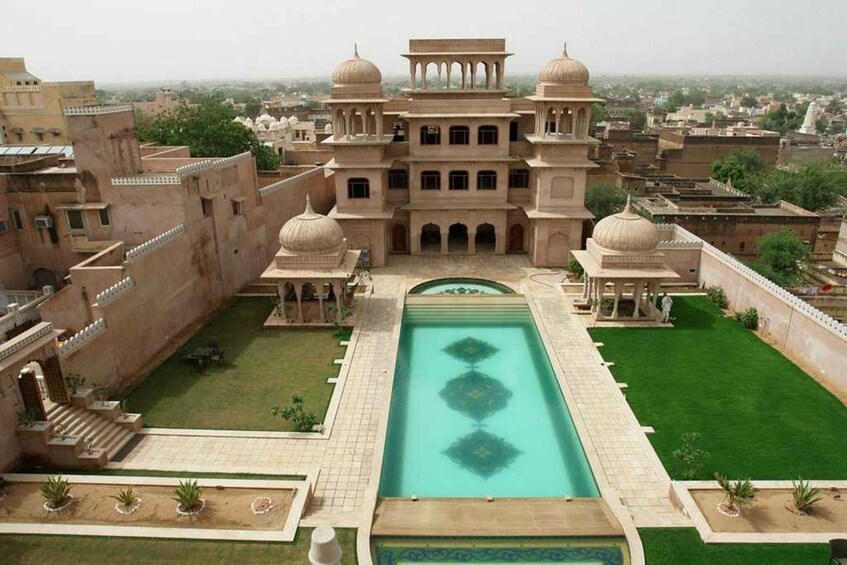 A large, ornate building with domed towers and a central courtyard with a pool. 3