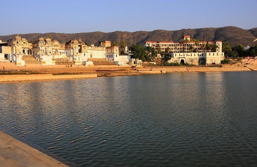 A river with buildings and mountains in the background. 1