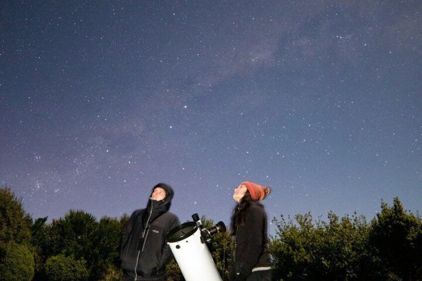 Two people observing the night sky through a telescope. 3