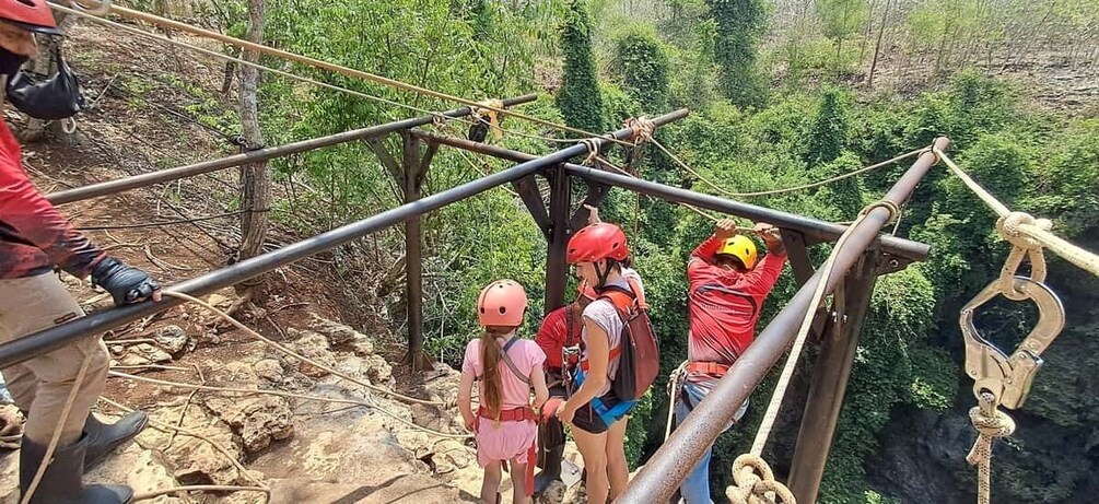 People on a rope bridge in a forested area. 2