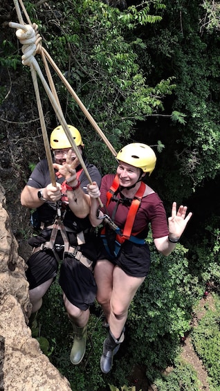 Two people rappelling down a rocky cliff with ropes and helmets. 4