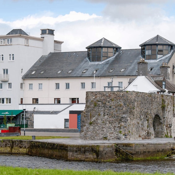 A stone wall, a building with a sloped roof, and a clear sky. 4
