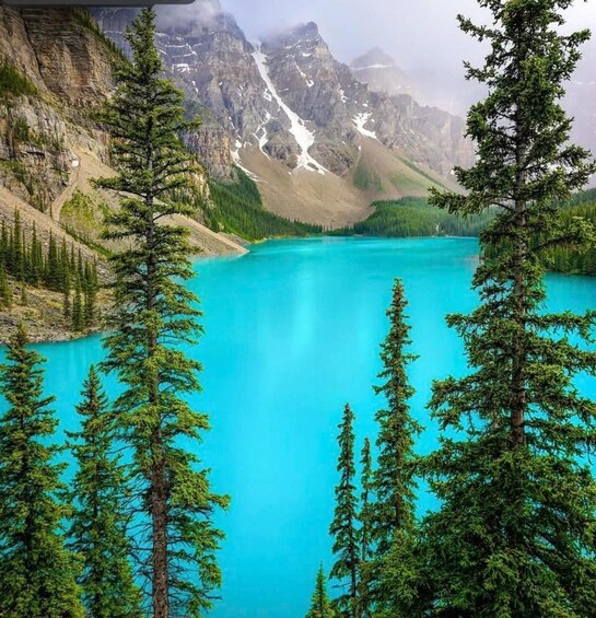 A turquoise lake surrounded by mountains and coniferous trees. 1