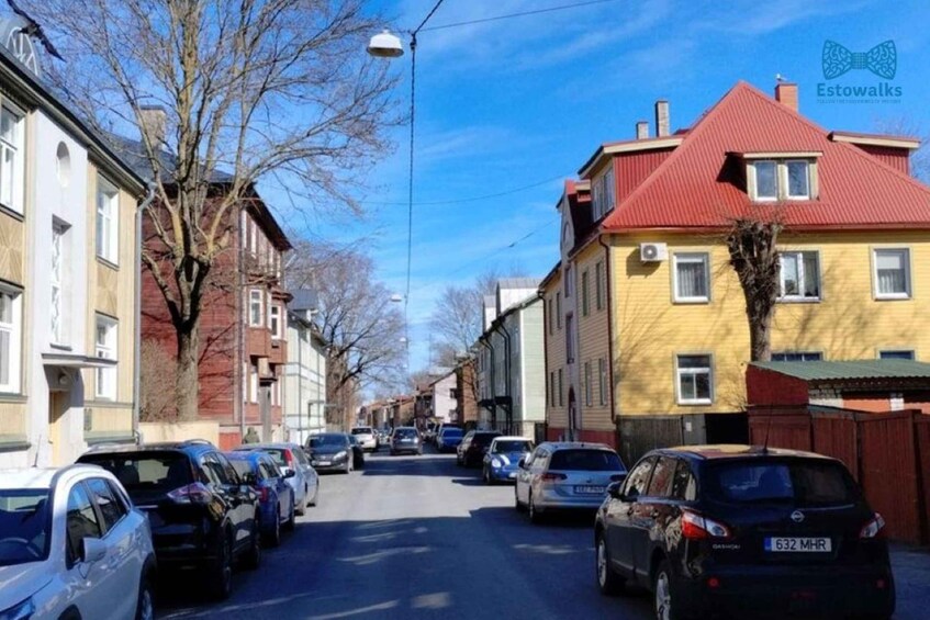 A street lined with parked cars and buildings. 1
