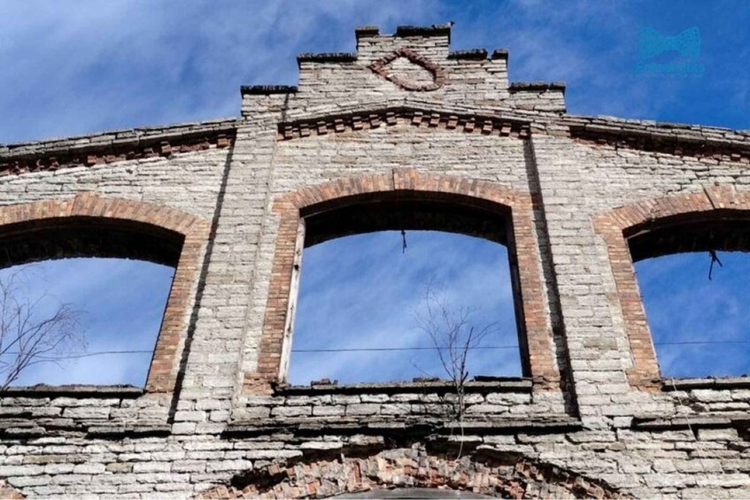 A stone structure with three arched windows and a decorative top. 5