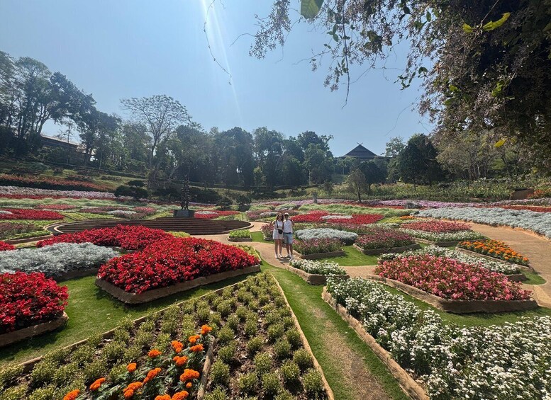 A garden with various flower beds and a central statue. 2