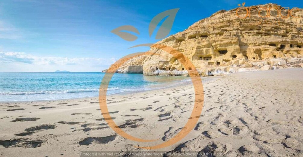 A beach with footprints and a cliff with caves. 3