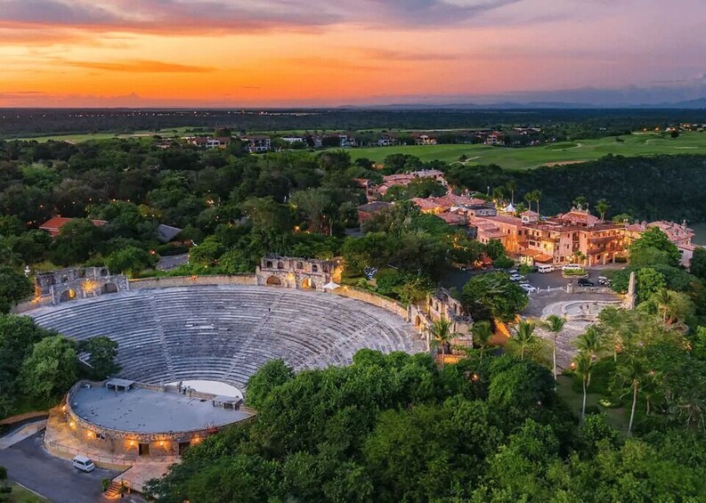 A historic amphitheater surrounded by lush greenery and a town with traditional architecture. 2