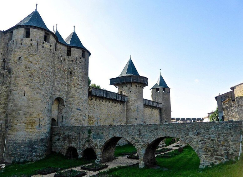 A medieval castle with multiple towers and a stone bridge. 1