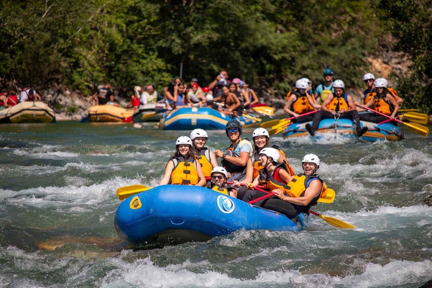 A group of people rafting on a river surrounded by greenery. 2