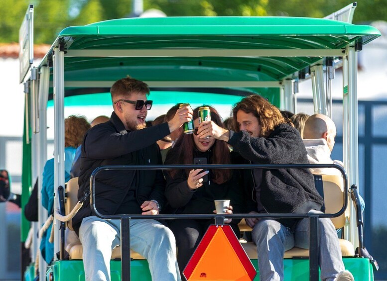People on a green trolley with a red and orange warning sign. 4