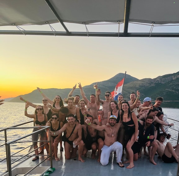 A group of people on a boat with a mountainous landscape in the background. 4