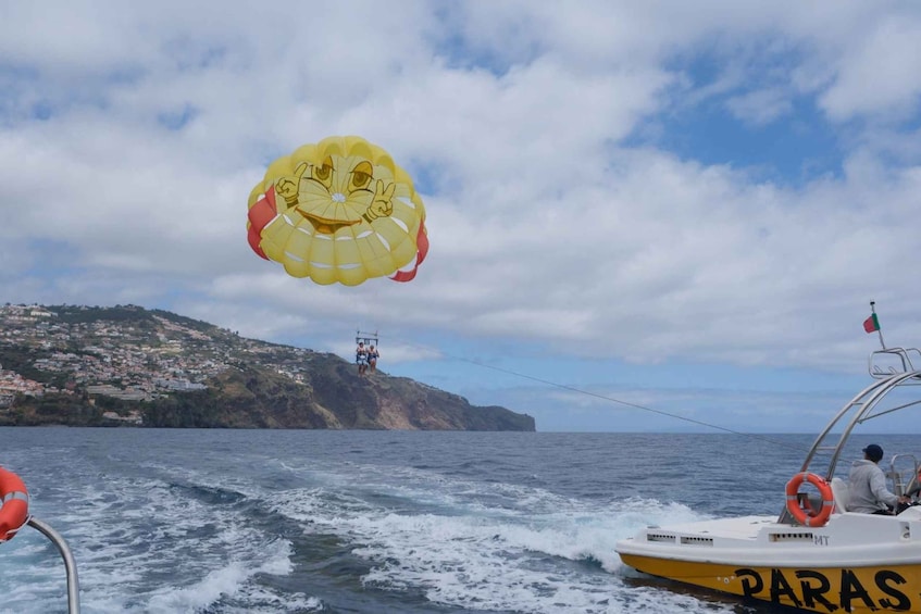 A parasailing activity with a yellow parasail and a boat named 'PARAS' in the water. 2