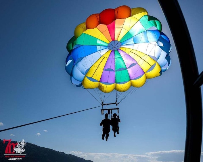 A colorful parachute with two people descending. 4