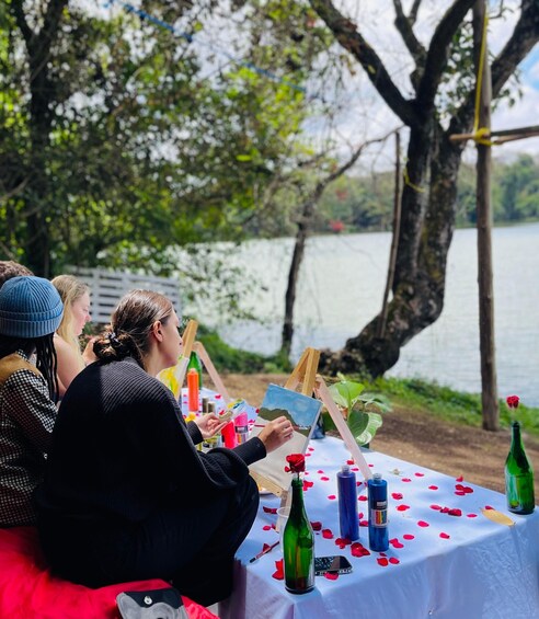 People painting outdoors by a lake. 3