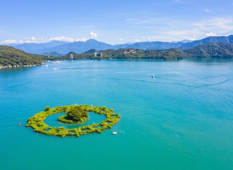 A circular island in a turquoise lake surrounded by mountains. 2