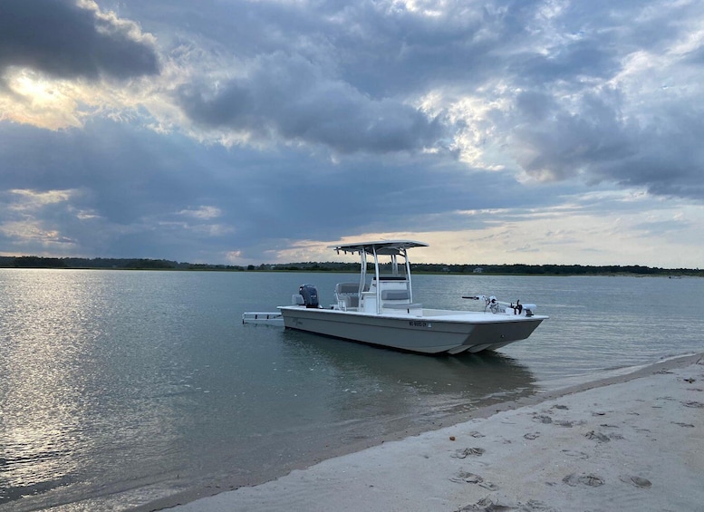 A boat docked at a sandy beach with a cloudy sky. 2