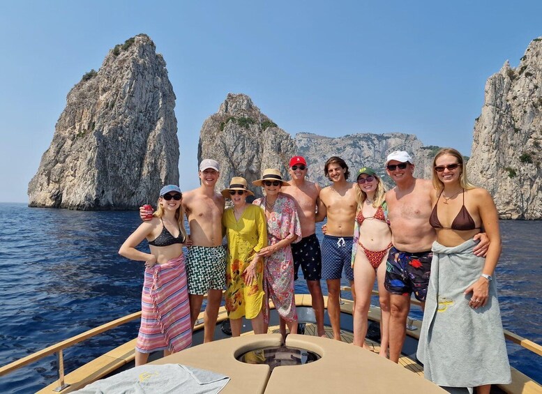 A group of people on a boat with rocky cliffs in the background. 3