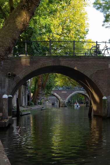 A brick bridge over a canal with trees and bicycles. 5