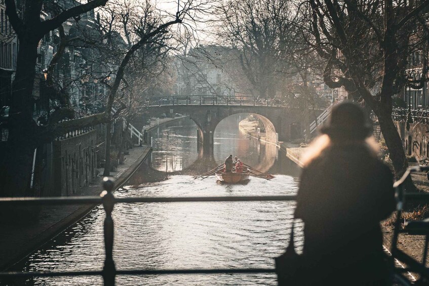 A river with a bridge and a boat with people. 5