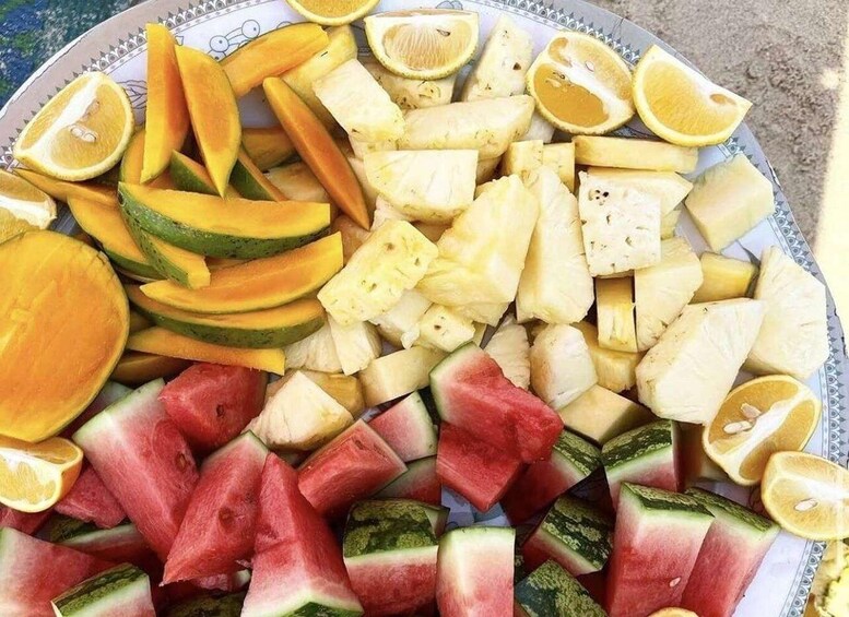 A plate of assorted fruits including watermelon, cantaloupe, pineapple, and oranges. 3