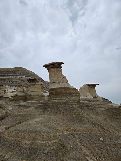 A landscape with prominent hoodoos and layered rock formations. 1