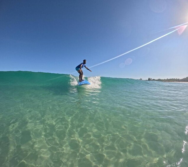 A person surfing on a clear blue ocean. 3