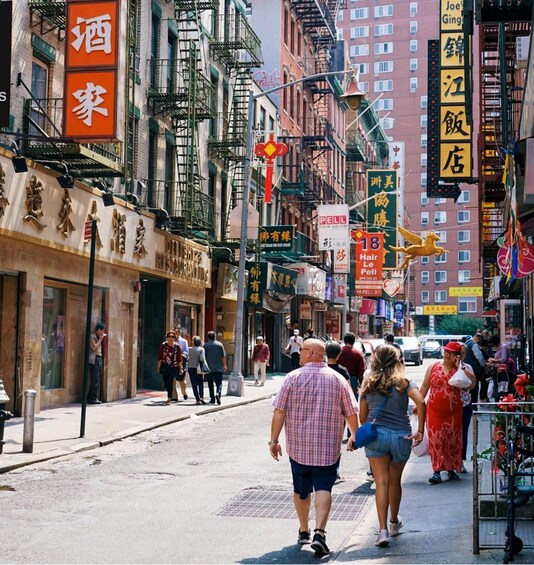 A busy street with pedestrians, shops, and various signs in a foreign language. 5
