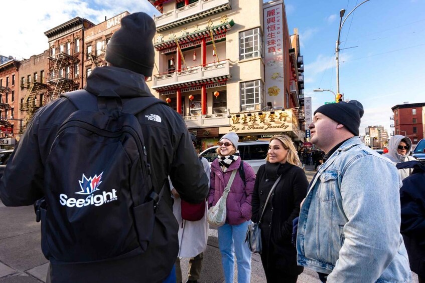 A group of people standing on a city street with buildings in the background. 3