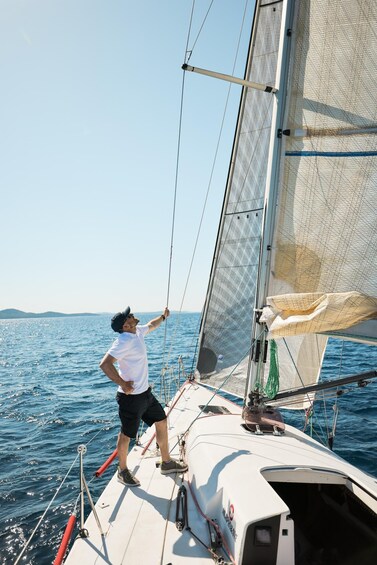 A person on a sailboat, adjusting the sail. 2