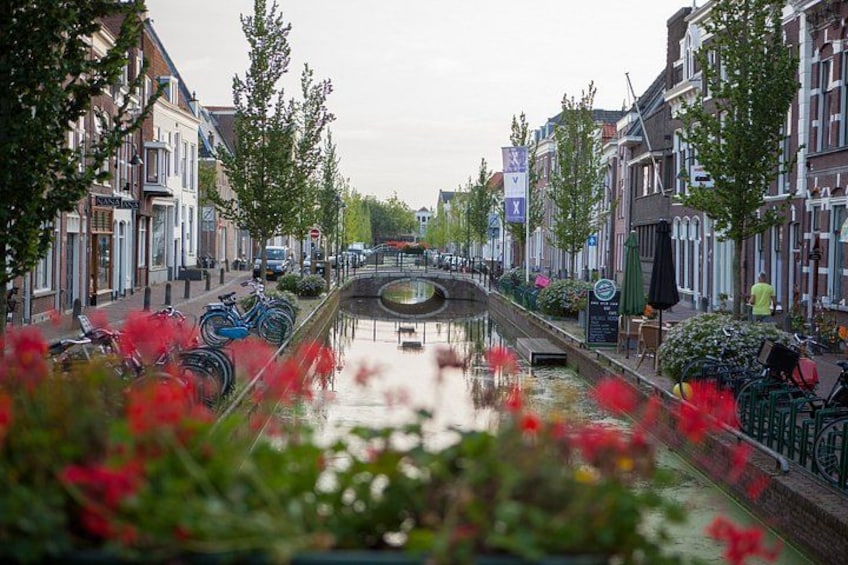 A canal with boats, lined with trees and buildings. 2