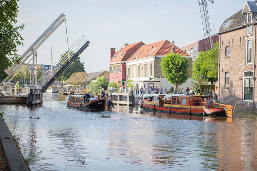 A canal with boats, a bridge, and buildings along the water. 3