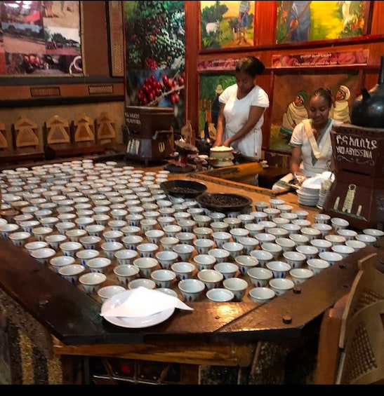 A large display of ceramic cups and bowls on a wooden table. 5