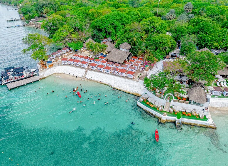 A tropical beach resort with clear turquoise waters, a dock with boats, and thatched-roof structures. 3