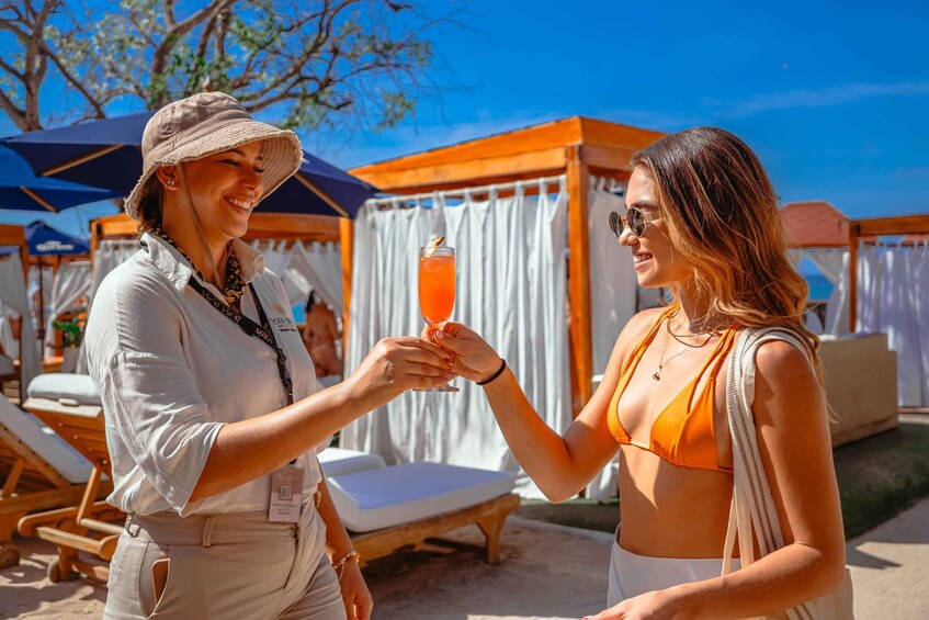 Two people toasting with a drink at a beachside resort. 4