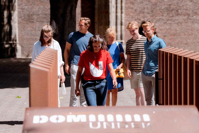 A group of people walking outdoors, some carrying bags. 1