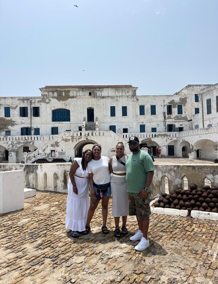 A group of people standing on a rooftop with a historic building in the background. 3