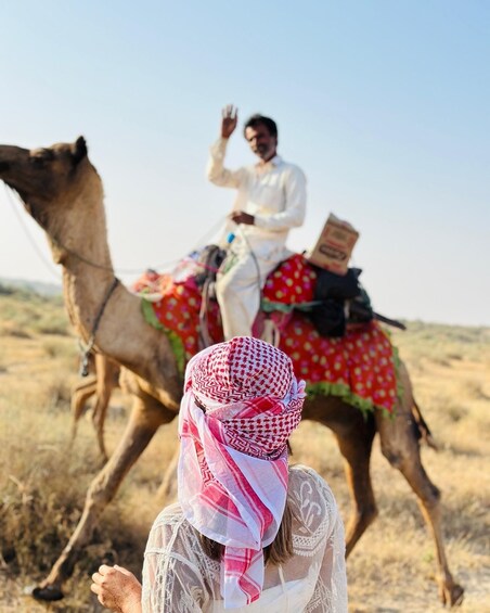 A person riding a camel in a desert landscape. 3