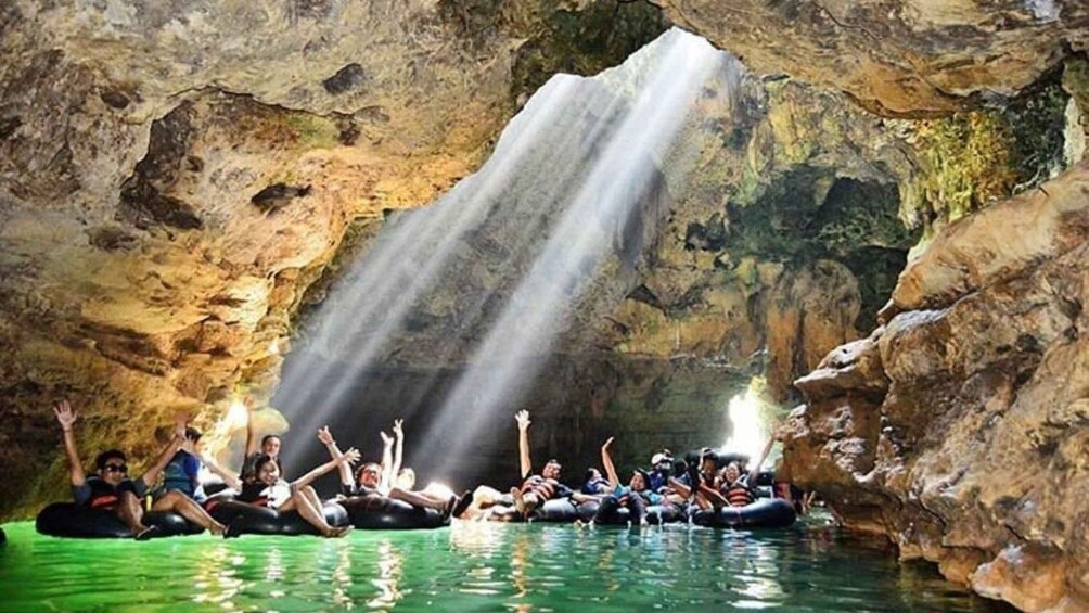 People rafting in a cave with a waterfall. 2