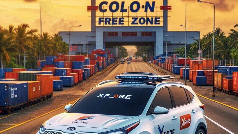 A white car with 'XP-CORE' and 'Xplore' logos parked in front of a 'COLON FREE ZONE' sign. 1