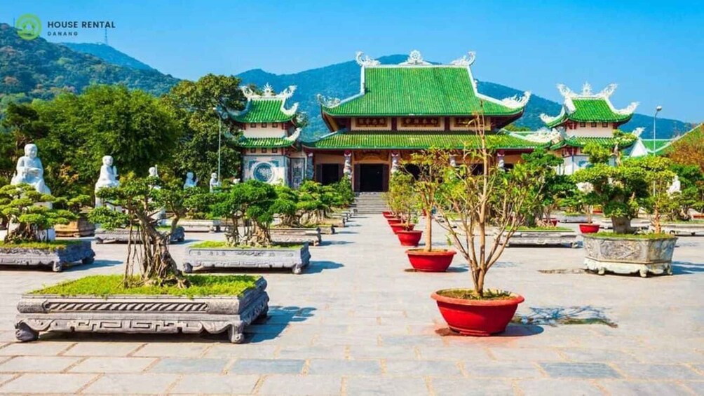 A traditional temple complex with multiple buildings, statues, and well-maintained gardens. 4