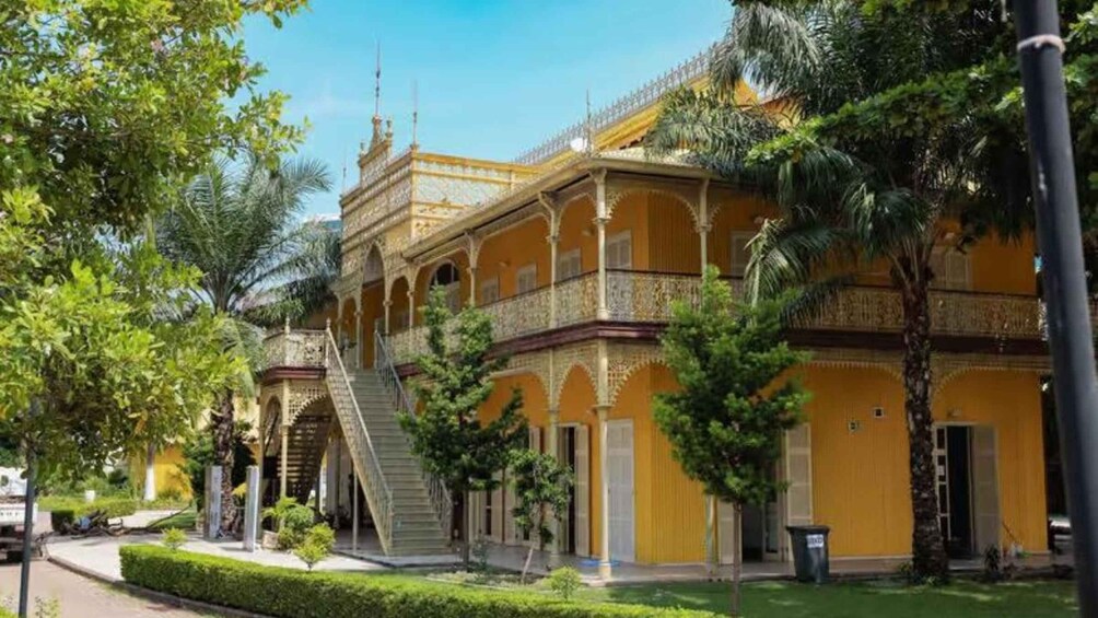 A historic yellow building with ornate balconies and a staircase. 4