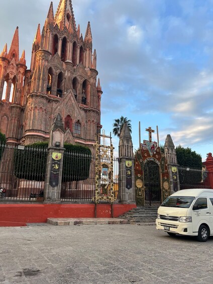 A Gothic-style cathedral with intricate architecture and a white van parked in front. 5