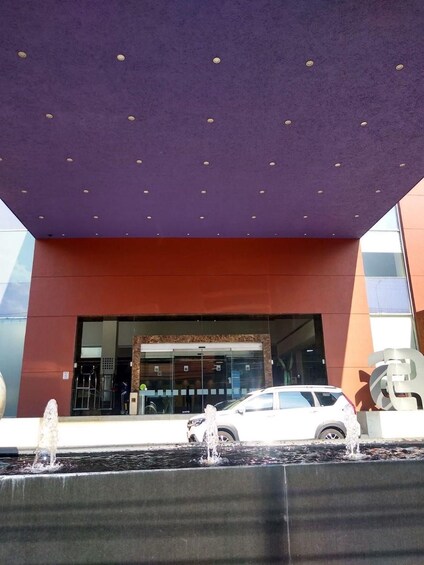 A modern building with a purple roof and a white car parked in front. 2