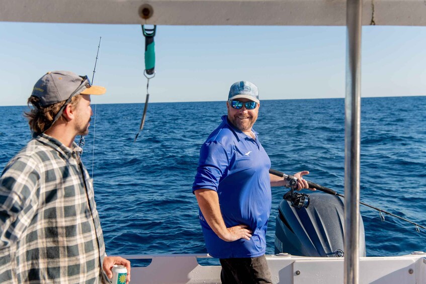 Two people on a boat with the ocean in the background. 3